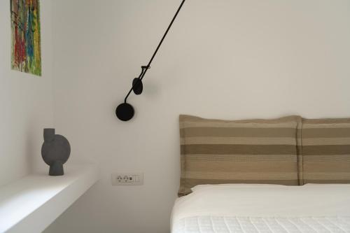 a bedroom with a bed with a lamp on the wall at TWO VAULTS, Rethymno old town in Rethymno