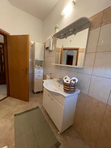 La salle de bains est pourvue d'un lavabo, d'un miroir et d'un réfrigérateur. dans l'établissement Apartman Josipa, à Biograd na Moru