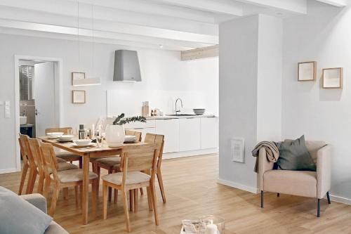 a dining room and kitchen with a table and chairs at Bi de Bark in Fehmarn