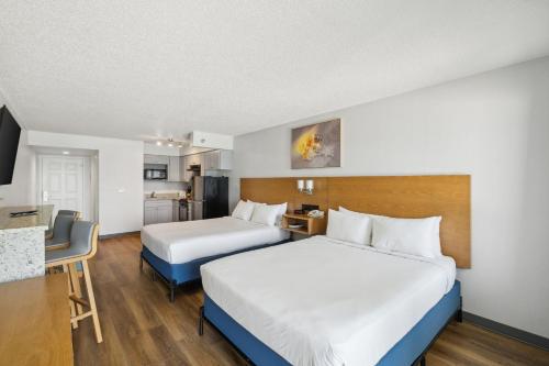 a hotel room with two beds and a kitchen at Sugar Sands Beachfront Hotel, a By The Sea Resort in Panama City Beach