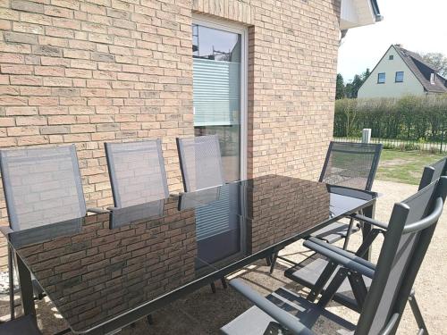 a patio table and chairs in front of a brick building at Kleenes Haffhus in Ueckermünde