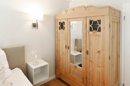 a bedroom with a wooden cabinet next to a bed at Bi de Bark in Fehmarn