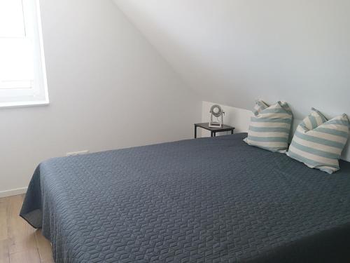 a bedroom with a bed with a blue comforter and pillows at Kleenes Haffhus in Ueckermünde