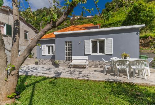 un patio con tavolo e sedie di fronte a una casa di Casa da Hortência do Faial a Faial