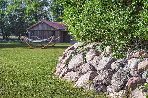 a rock retaining wall with a hammock in a yard at Bi de Bark in Fehmarn