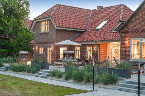 a brick house with a table and an umbrella at Bi de Bark in Fehmarn