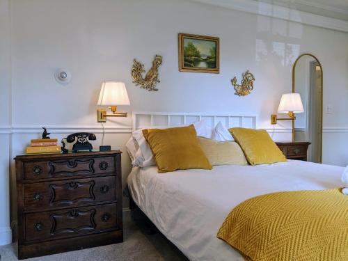 a bedroom with a bed and a dresser and two lamps at Stanton House Inn in Greenwich