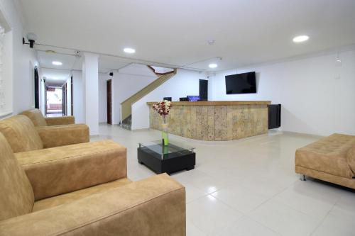 a living room with two couches and a tv at Hotel Rodadero Inn By GEH Suites in Santa Marta