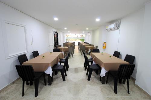 a row of tables and chairs in a room at Hotel Rodadero Inn By GEH Suites in Santa Marta