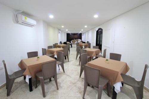 a row of tables and chairs in a restaurant at Hotel Rodadero Inn By GEH Suites in Santa Marta
