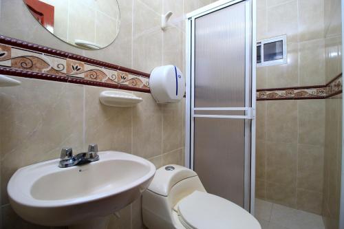 a bathroom with a toilet and a sink and a shower at Hotel Rodadero Inn By GEH Suites in Santa Marta