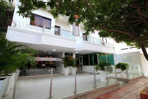 a building with a courtyard with potted plants at Hotel Rodadero Inn By GEH Suites in Santa Marta
