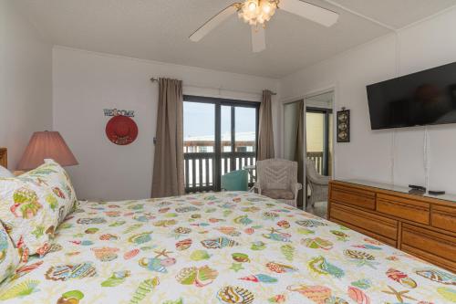 een slaapkamer met een bed, een televisie en een dressoir bij Tiki 224 in South Padre Island