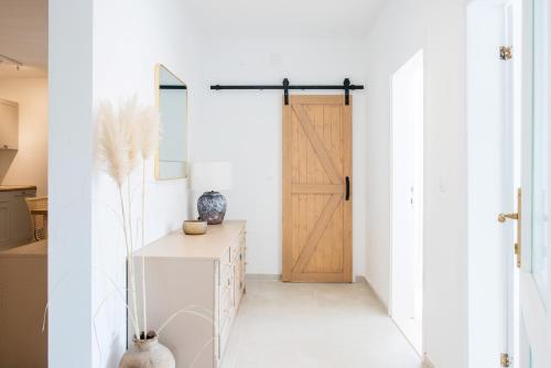 a hallway with a wooden door and a table at Propela apartments in Božava