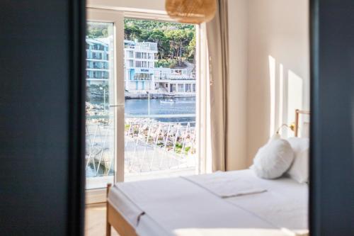 a bedroom with a window with a view of a harbor at Propela apartments in Božava