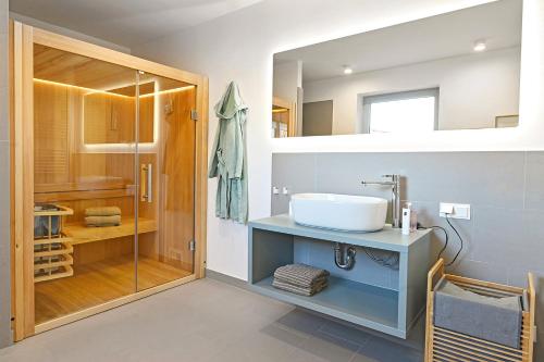 ein Bad mit einem Waschbecken und einer Dusche in der Unterkunft Op de Düün in Fehmarn
