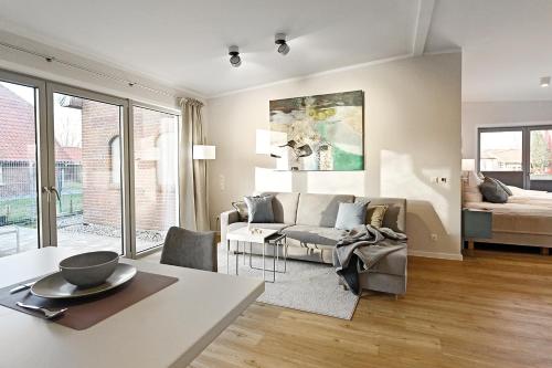 ein Wohnzimmer mit einem Sofa und einem Bett in der Unterkunft Op de Düün in Fehmarn
