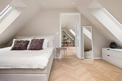 a white bedroom with a white bed and a staircase at Dinbnb Apartments I Mid-City Luxury with Mini Balcony and Smart TV & Sound System in Bergen
