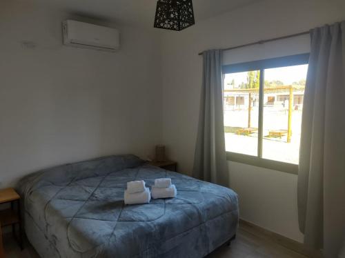 a bedroom with a bed with two towels on it at Buenas Tierras Cabañas in San Rafael