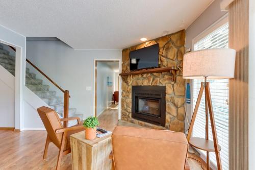 a living room with a stone fireplace and a chair at Lakefront Retreat in the Heart of Osage Beach! in Osage Beach