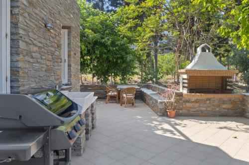 a backyard with a barbecue grill and a brick building at The Secret Valley of Chora - 5 mins to Beach in Livádhia