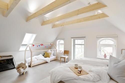 a white bedroom with a large bed and a fireplace at Kleene Slott in Fehmarn