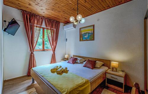 a bedroom with a bed with shoes on it at Nice Home In Lumbarda With Outdoor Swimming Pool in Lumbarda