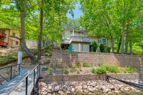 a house on a brick wall with stairs and trees at Lakefront Retreat in the Heart of Osage Beach! in Osage Beach