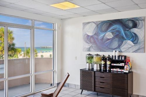 a room with a table with wine bottles and a window at Holiday Terrace Beachfront Hotel, a By The Sea Resort in Panama City Beach