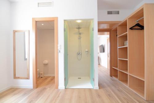 a walk in shower in a room with a closet at Apartamentos Playa Sol in Es Cana