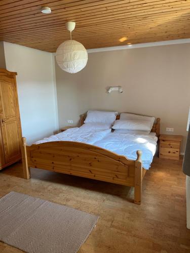 Schlafzimmer mit Holzbett und Holzdecke in der Unterkunft Dreher Hof Salem in Salem