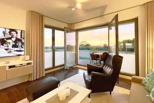 a living room with a television and a table and chairs at Villa Deichgraf 12 "Meerblick" in Börgerende-Rethwisch
