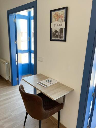 a table and a chair with a sign on a wall at O Refuxio do Náufrago in Camelle