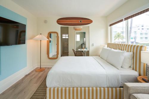 1 dormitorio con 1 cama blanca grande y 1 sofá en Aloha Fridays, en Miami Beach