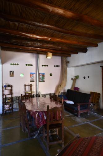 a room with a table and chairs and a couch at Tilcara Rustica Hostel in Tilcara