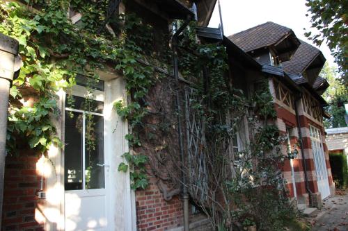 a building covered in ivy with a white door at Les Hauts du Plateau in Châtillon