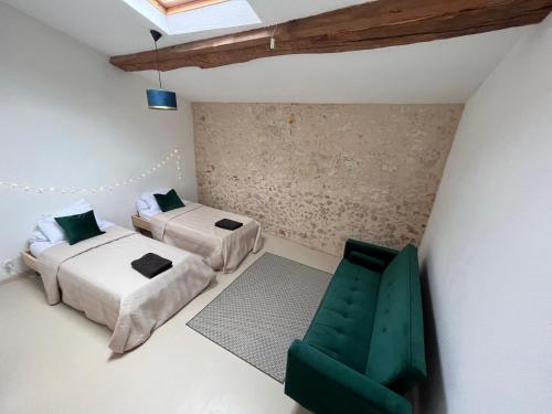 une chambre avec deux lits et une chaise verte dans l'établissement No 10 Vic Fezensac, à Vic-Fezensac