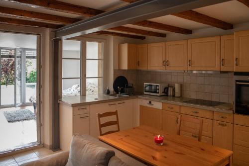 uma cozinha com armários de madeira e uma mesa de madeira em Auberge de La Couronne em Mies