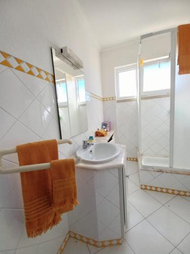 a white bathroom with a sink and a shower at Casa do Portão Azul - Espadarte in Atouguia da Baleia