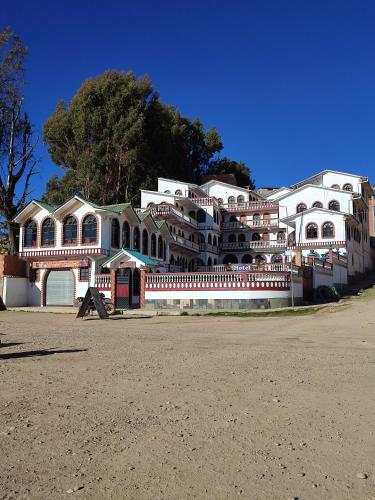 a large white building on the side of a road at Hotel Chasqui del Sol in Copacabana