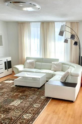ein Wohnzimmer mit einer weißen Couch und einem Teppich in der Unterkunft Blackforest FeWo in Freudenstadt