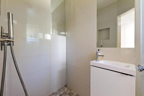 a white bathroom with a sink and a shower at 29 Smithwood close in London