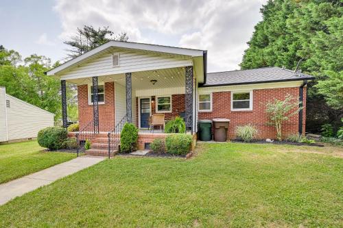 a brick house with a porch and a lawn at Greensboro Vacation Rental 2 Mi to Downtown! in Greensboro