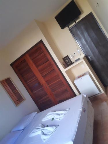 um quarto com uma cama e uma porta de madeira em Pousada Encontro das águas em Fortaleza