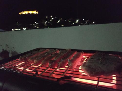 a grill with meat on top of it at night at Villa Kotetsi - Rooms To Let - Volissos - Chios in Volissos