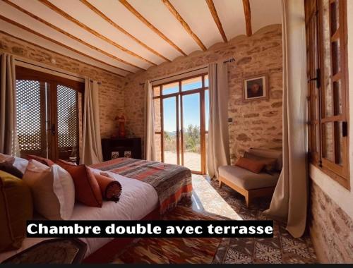 a bedroom with a bed and a large window at Villa des Hauts Mogador in Essaouira