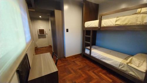 Habitación con 2 literas y mesa. en Dallas Hotel -Motel- en Buenos Aires