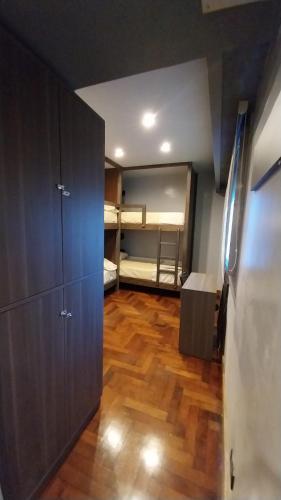 una habitación con suelo de madera y una habitación con literas en Dallas Hotel -Motel- en Buenos Aires