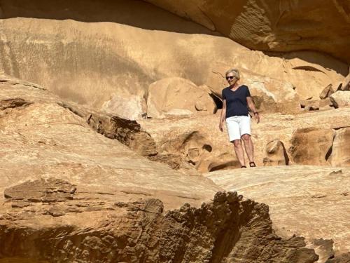 a woman standing on some rocks in a canyon at Yara camp in Wadi Rum