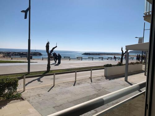 a sidewalk next to a beach with people walking at Apart. en 1ra línea+pkg privado in Sant Antoni de Calonge